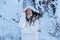 Portrait of beautiful, young, secy, cute, brunette woman, freezing in the cold winter in white coat and hood, lying surreal like