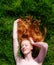 Portrait of a beautiful young sexy red-haired woman, lying in the spring sun in happiness, relaxing on the green grass, the red