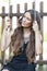 Portrait of beautiful young teenage girl in a dress while sitting on a wooden swing at the park