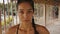 Portrait of beautiful young tired and sweaty woman boxer turning face to camera with serious look. Close up of pretty