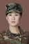 Portrait of beautiful young US Marine Corps soldier in camouflage clothing over brown background