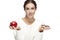 Portrait of a beautiful young woman, choosing between apple and donut