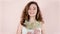 Portrait. Beautiful young woman with curly brown hair on a light background with flowers in her hands and smiling