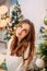 Portrait of a beautiful young woman dreaming in festive decorated bedroom