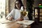 Portrait of a beautiful young woman drink white wine and having rest in cafe near window