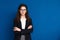 Portrait of beautiful young woman in formal clothes on color background