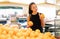 Portrait of beautiful young woman holding shopping orange in supermarket. Customer in food store, Happy lifestyle or shopaholic