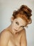 Portrait of a beautiful young woman with long red curly hair and freckles