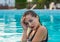 Portrait of a beautiful young woman in the pool. Woman is relaxing in a pool.