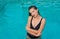 Portrait of a beautiful young woman in the pool. Woman is relaxing in a pool