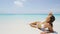 Portrait of beautiful young woman running hand through hair on tropical beach