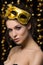 Portrait of beautiful young woman wearing golden party mask