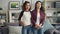 Portrait of beautiful young women Asian and African American standing at home together, looking at camera and smiling