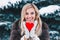 Portrait of a beautifull smiling woman in winter forest holding red Valentine`s heart in the hands.