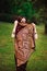 Portrait of beauty Indian model with bright make-up who hiding her face behind the veil. Young Hindu woman with mehndi