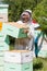 Portrait Of Beekeeper Working At Apiary