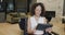 Portrait of biracial businesswoman in wheelchair using tablet in office and smiling, in slow motion