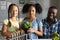 Portrait of biracial elementary schoolgirls with plant standing by african american young teacher