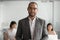 Portrait of biracial male employee in glasses posing at workplace