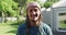 Portrait of biracial man with hat and dreadlocks outside on terrace of house smiling in the sun