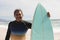 Portrait of biracial senior man holding surfboard at beach against sky during sunny day