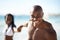 Portrait of black couple on beach, holding hands and smile on holiday with sunshine, tropical island and travel. Sea