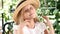 Portrait of blond attractive girl smiling, touching her hair with a straw hat on. Lifestyle. Happy childhood concept