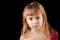 Portrait of blond Caucasian little girl on black