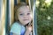 Portrait of blond child girl, relaxing on a colorful hammock