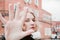 Portrait of blonde curly girl looking through her fingers