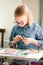 Portrait of blonde girl with big black glasses smiling happily while enjoying art and craft lesson in art school working together