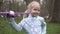 Portrait of blonde girl child with toy plane in outdoor spring park