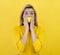 Portrait of a blonde girl with yellow tape taped her mouth. Censored, muted concept on yellow background