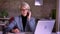 Portrait of blonde short-haired businesswoman in glasses seriously talking on cellphone in office.
