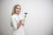 Portrait of blonde woman dermatologist with dermatoscope in white lab coat and white gloves on the white background