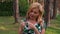 Portrait blonde woman guessing on white chamomile in summer forest