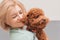Portrait blonde woman hugging curly Toy poodle
