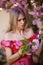 portrait of a blonde woman next to a blooming Japanese cherry tree