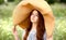 portrait of a blue-eyed girl in a big wicker hat outdoors in summer. Fashion and beauty. Meditation and relaxation Ñoncept
