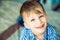 Portrait of a blue-eyed little smiling boy lying on his parents\' bed.