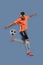 Portrait with blurring effect. Young male soccer or football player kicking ball for the goal in jump. Concept of sport