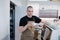 Portrait of a bold male baker posing with coffee cup in hands