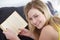Portrait, book and woman relax on a bed with a novel, happy and enjoying a day off in her home. Face, smile and female