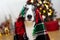 Portrait border collie wrapped with a warm wool blanket sitting under christmas tree lights