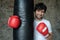 Portrait boxing guy posing next to punch bag in gym