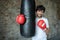 Portrait boxing guy posing next to punch bag in gym