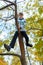 Portrait of a boy in an autumn park. The child climbed a tree and playing