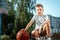 Portrait of a boy with a basketball on a basketball court. The concept of a sports lifestyle, training, sport, leisure, vacation