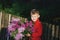Portrait of a boy with a bouquet of lilacs .
