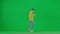 Portrait of boy on chroma key green screen. School boy kid in casual clothing walking and playing video game on